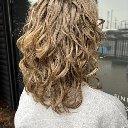 Client with soft blonde waves after a curly cut at Curls Done Wright